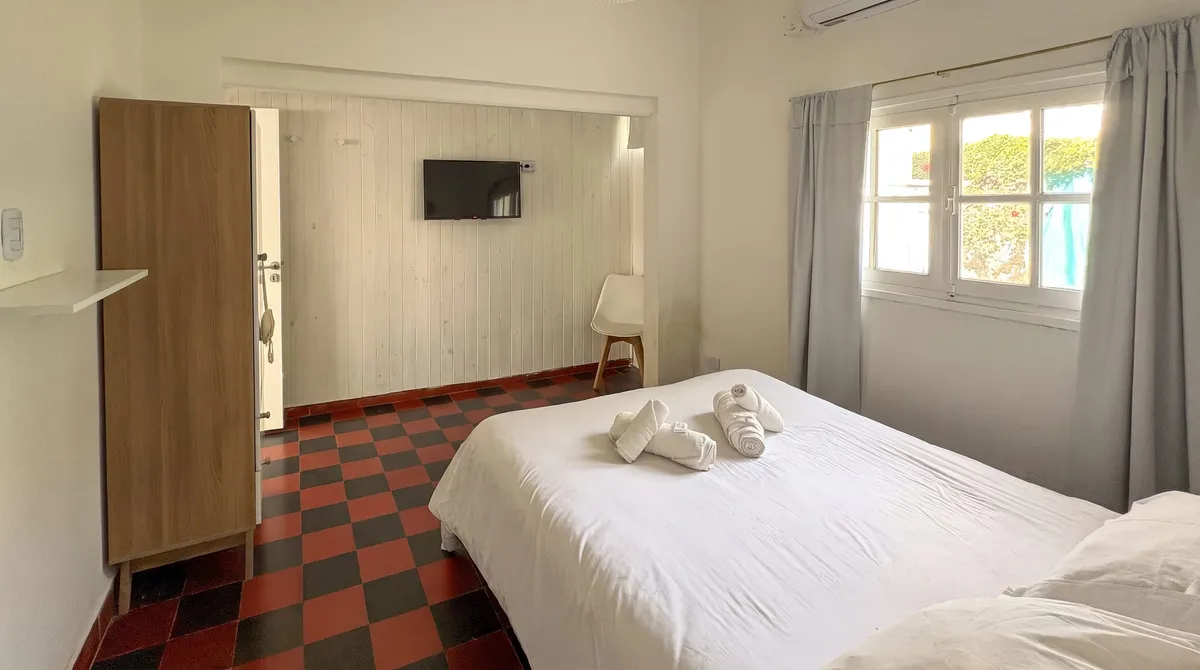La habitación desde la puerta, con Smart TV y placard