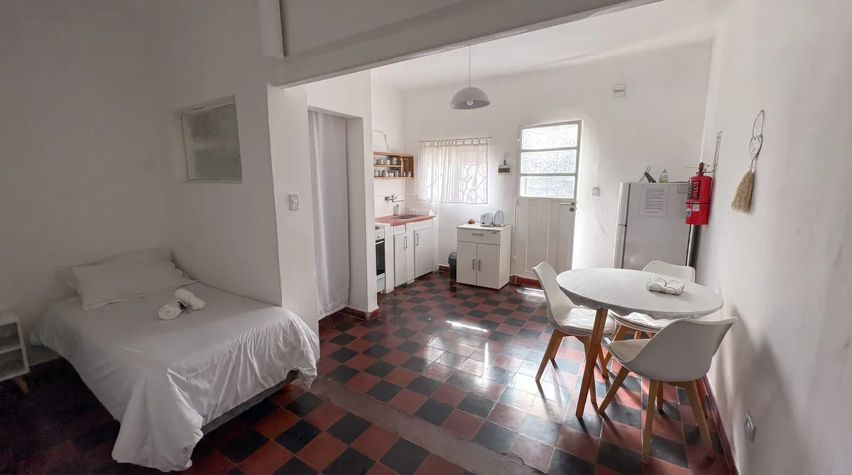 El ambiente integrado: cocina, mesa y la cama individual